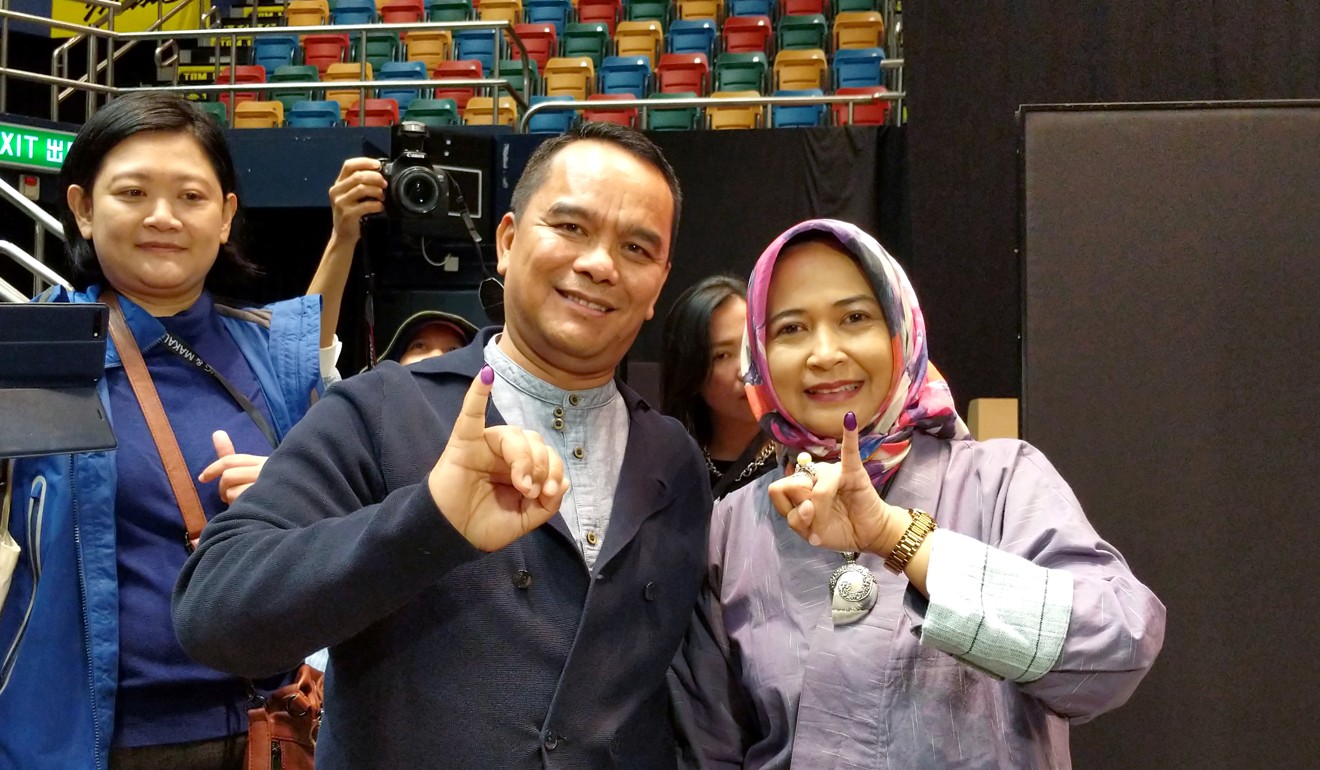 Indonesian consul general Tri Tharyat shows off his inky pinkie – a measure to prevent repeated voting. Photo: Sum Lok-kei