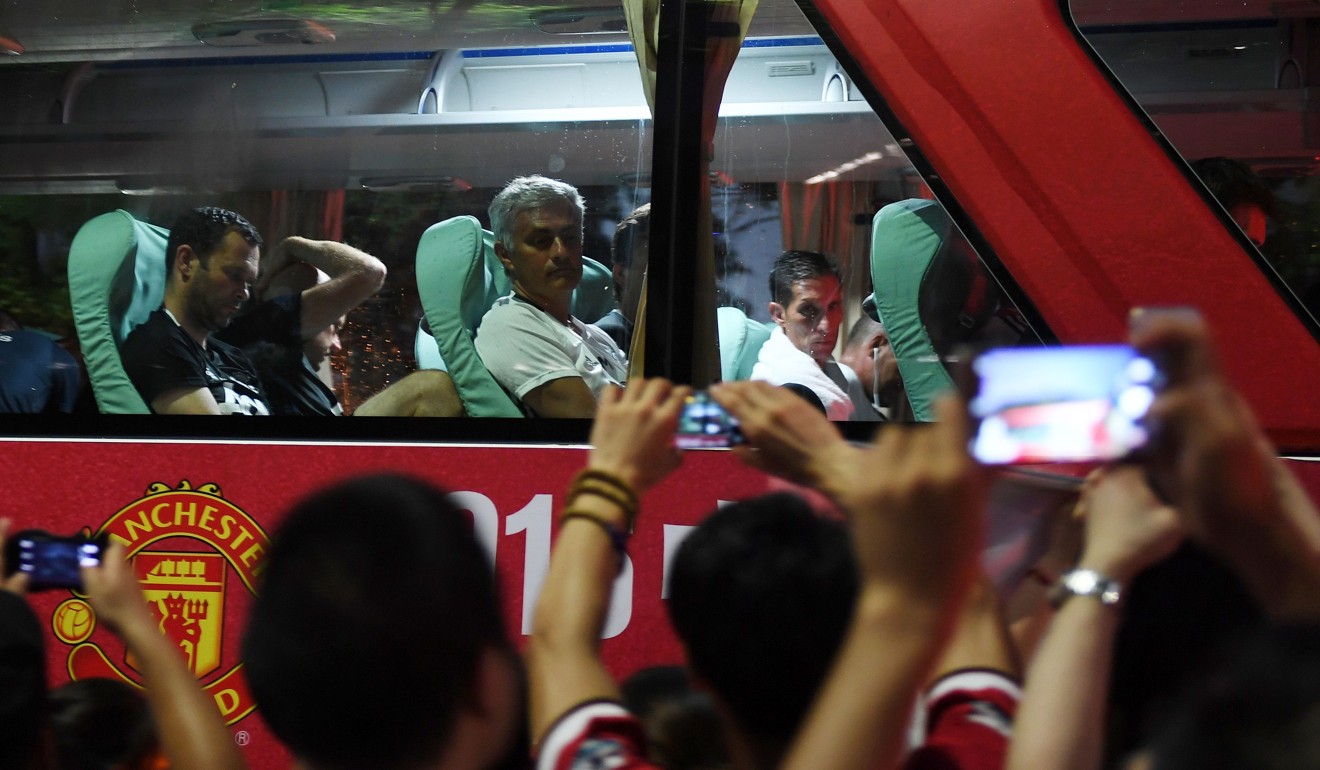 Manchester United coach Jose Mourinho (centre) looks at fans from the team bus in Beijing in 2016. Photo: AFP