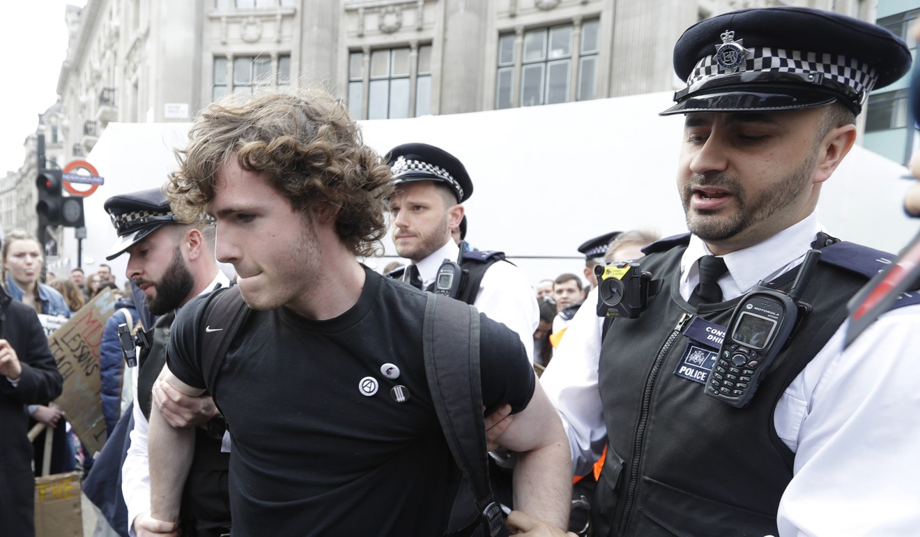 A demonstrator is detained for sitting in the road at Oxford Circus in London. Photo: AP Photo