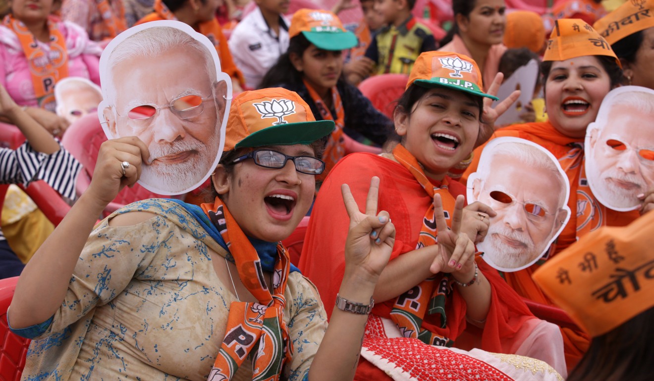 Supporters hold up masks of Prime Minister Narendra Modi at his campaign rally in Kathua, near Jammu, on April 14. Photo: EPA-EFE