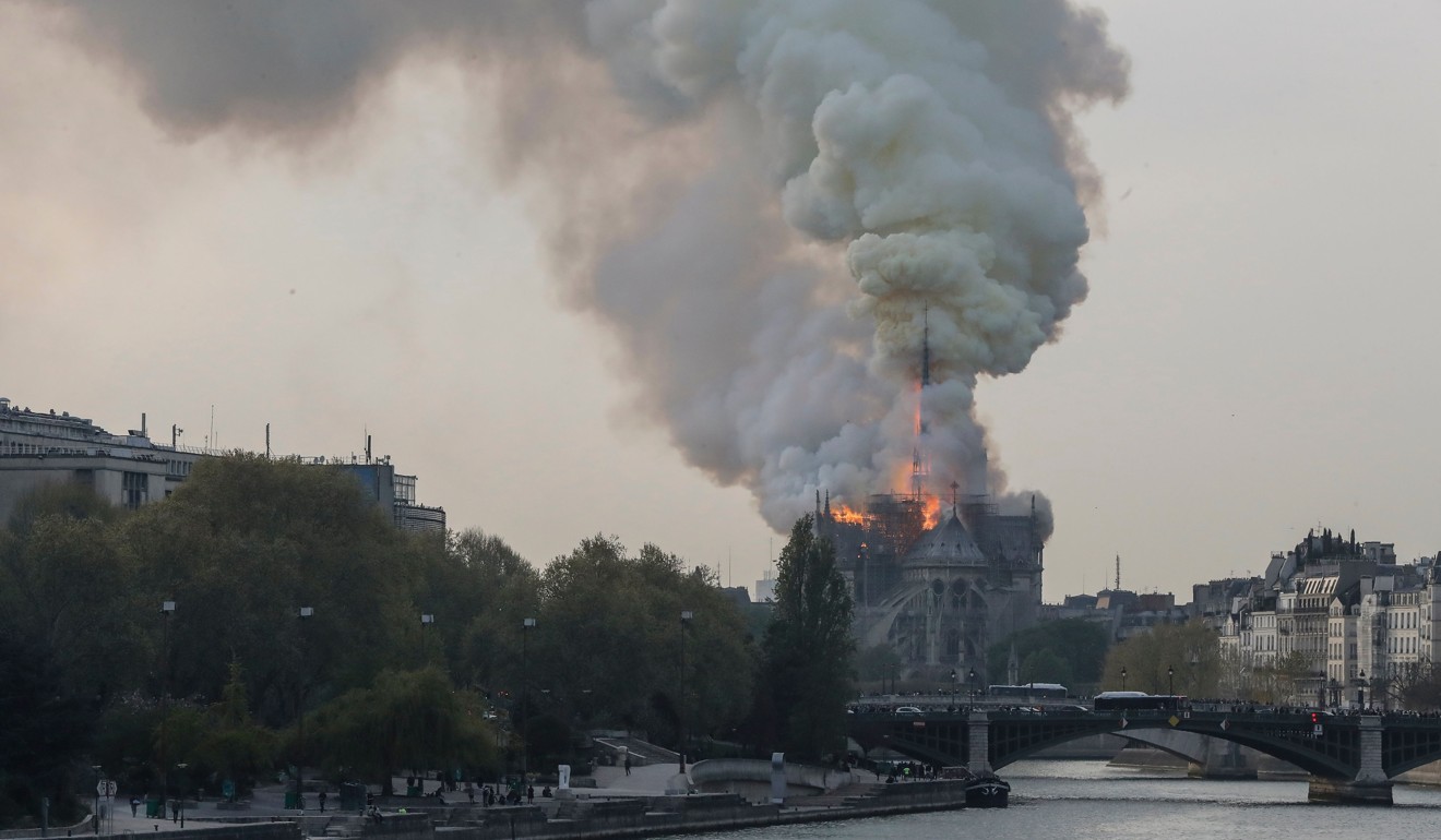 Smokes ascends as flames rise during a fire at the landmark Notre Dame Cathedral in central Paris on Monday, April 15, 2019. Photo: AFP