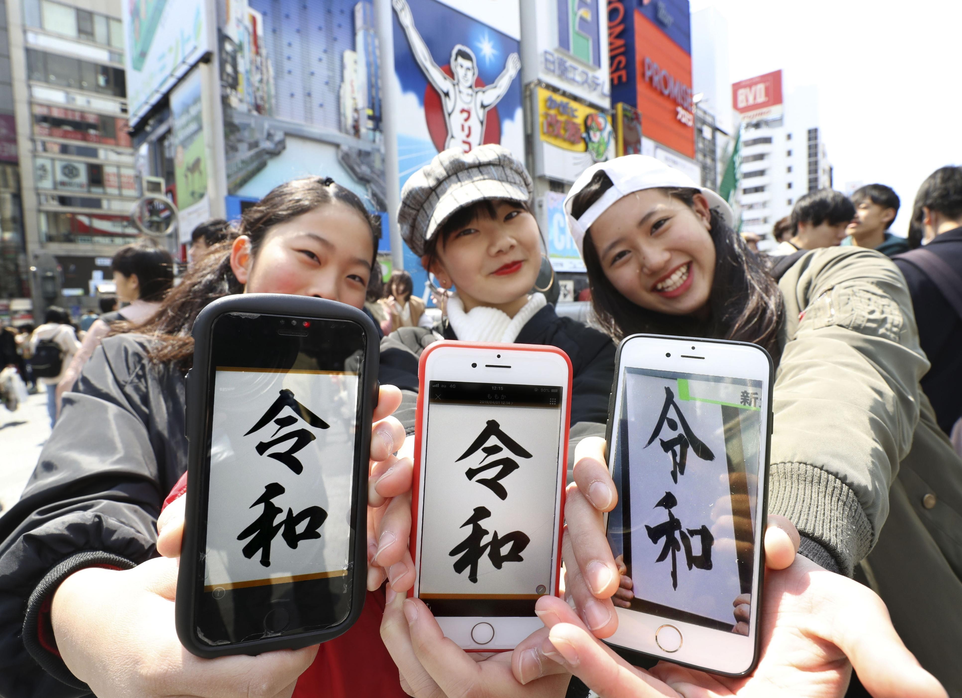 Women show smartphone screens with the name of Japan’s new era, “Reiwa”, in Osaka on April 1, following its announcement by the government earlier in the day. Photo: Kyodo