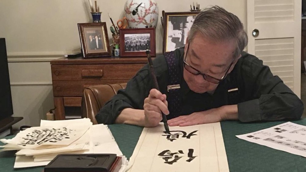 Professor Chi Wang, a scholar and collector of Chinese art, practising calligraphy. Photo: courtesy of Professor Chi Wang