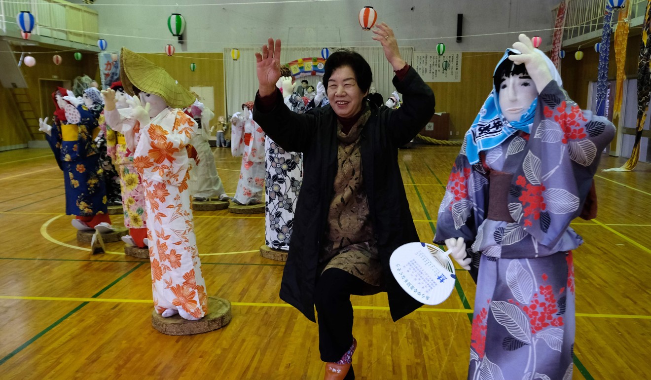 Tsukimi Ayano posing with life-size dolls displayed at a school, which closed seven years ago as there was no one left to teach, in the tiny village of Nagoro. Photo: AFP
