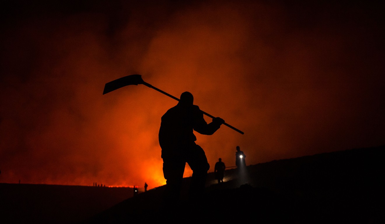 Firefighters tackle the blaze on moorland above the village of Marsden, northwest England, on April 21, 2019. Photo: AFP