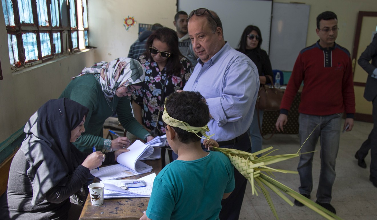 A child holds palm leaves at polling station during second day of the referendum. Photo: EPA-EFE