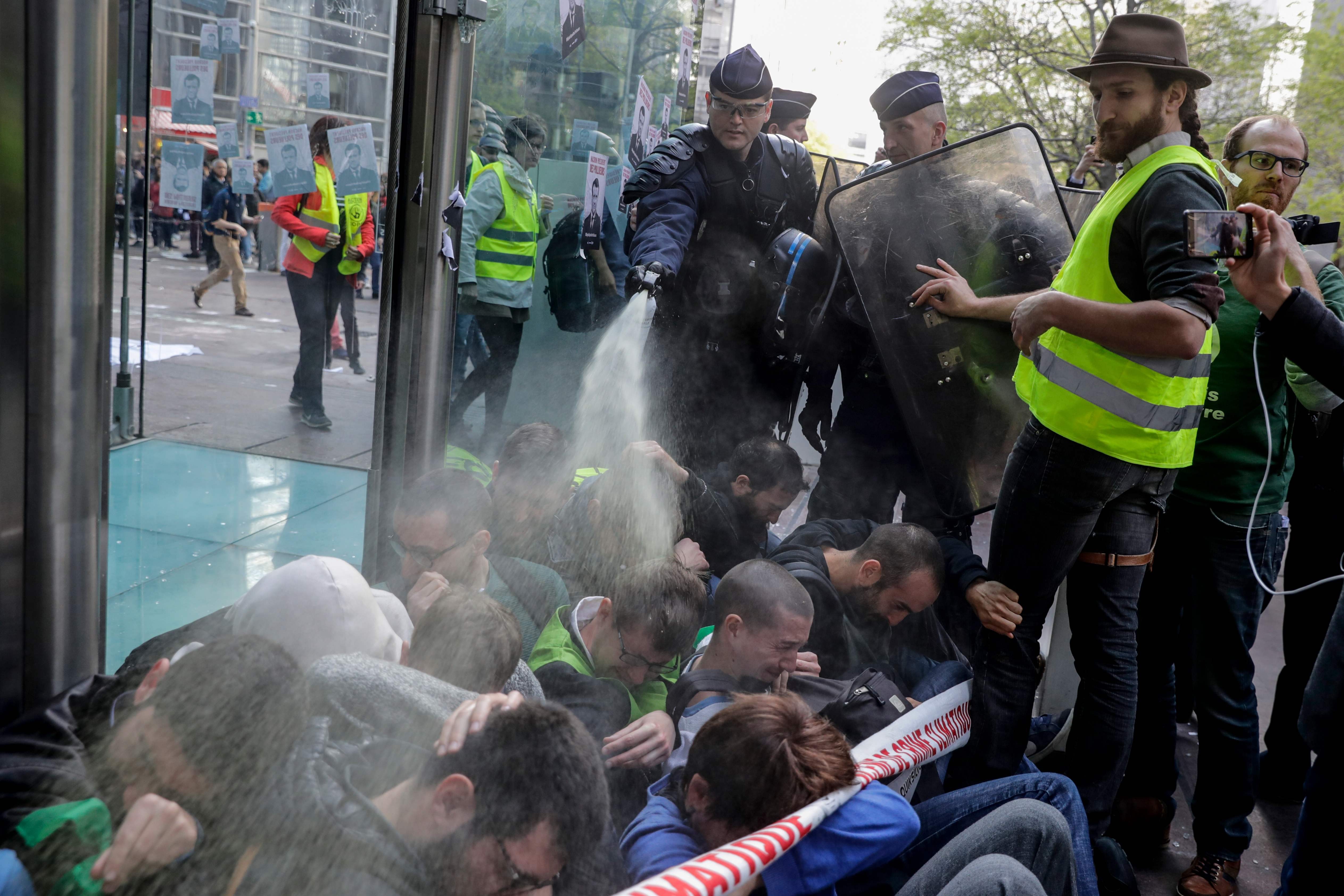 French police use pepper spray at close range on climate change activists blocking the entrance of the Societe Generale bank headquarters near Paris, during an Extinction Rebellion demonstration on April 19. Photo: AFP