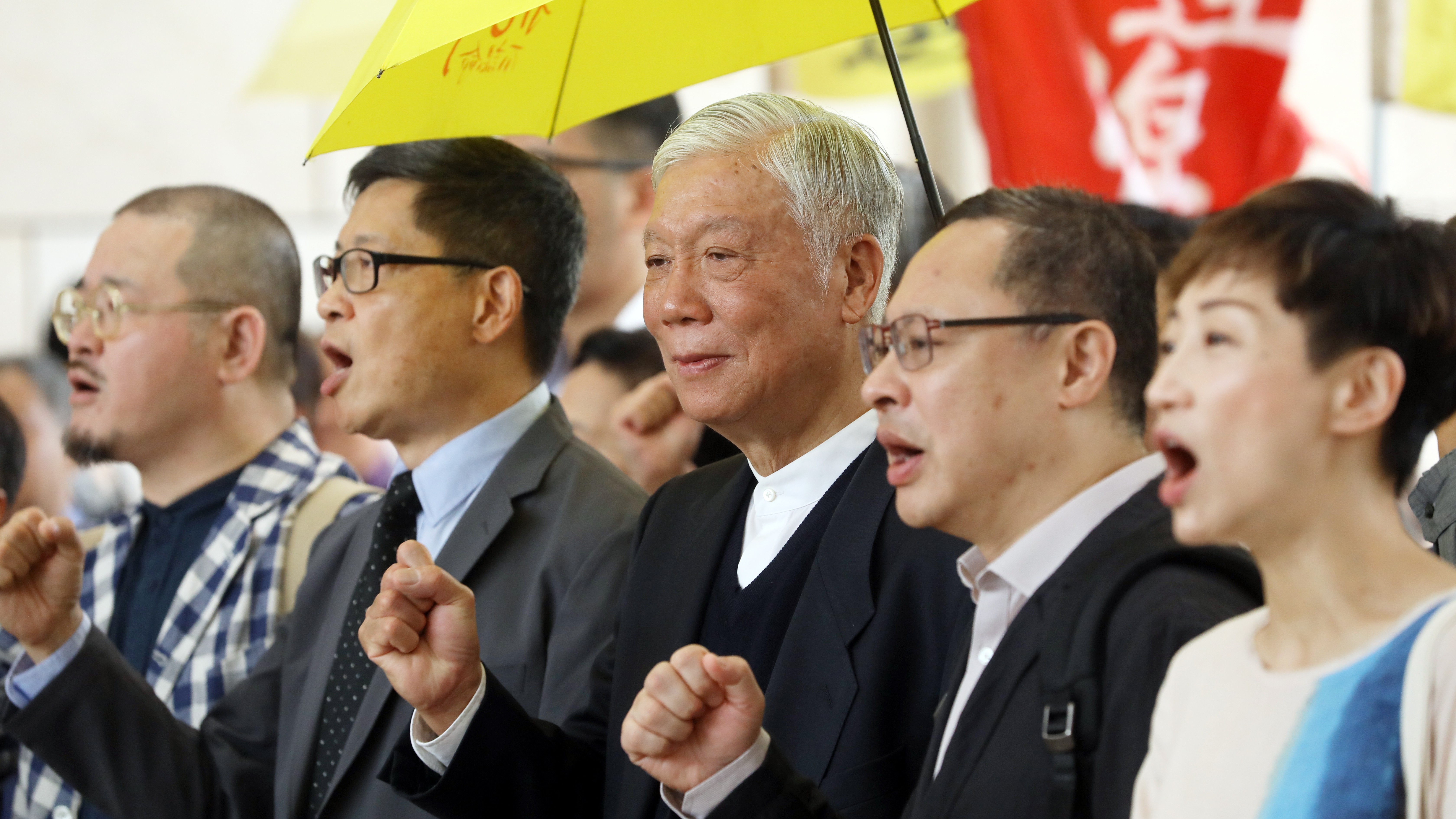 (From left) Lawmaker Shiu Ka-chun, co-founders of the Occupy movement Chan Kin-man, Chu Yiu-ming and Benny Tai Yiu-ting, and lawmaker Tanya Chan chant slogans outside the West Kowloon Court in Sham Shui Po, where they were tried for their participation in the Occupy protests, on April 10. Photo: Sam Tsang