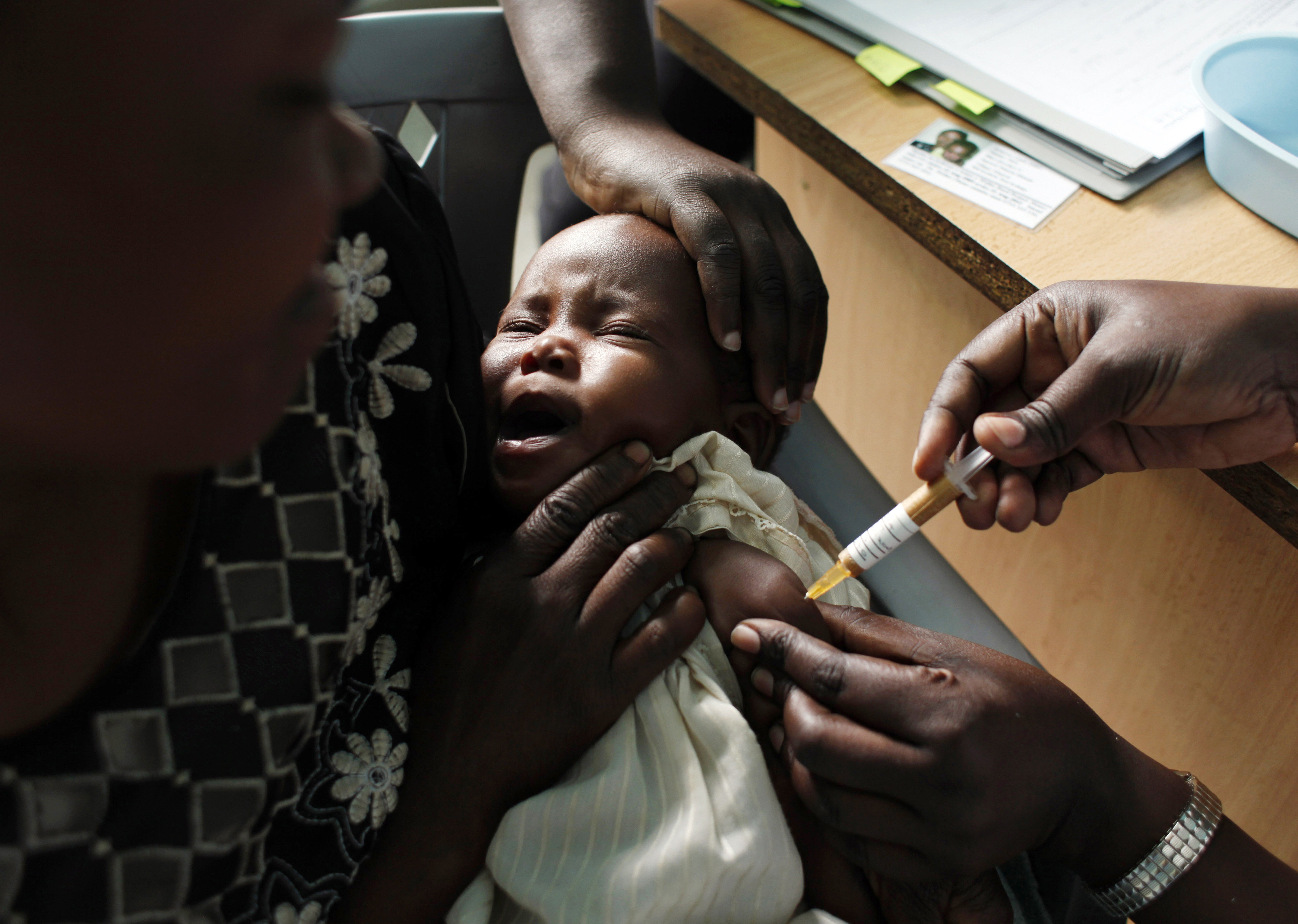 A mother holds her baby, who is receiving a new malaria vaccine as part of a trial in October 2009. Photo: AP