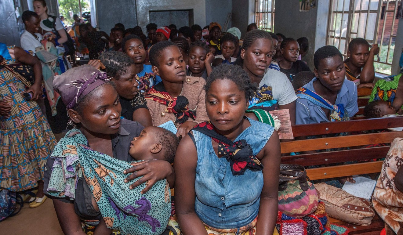 Mothers wait for their children to receive treatment at the beginning of the malaria vaccine pilot programme on Tuesday. Photo: AFP