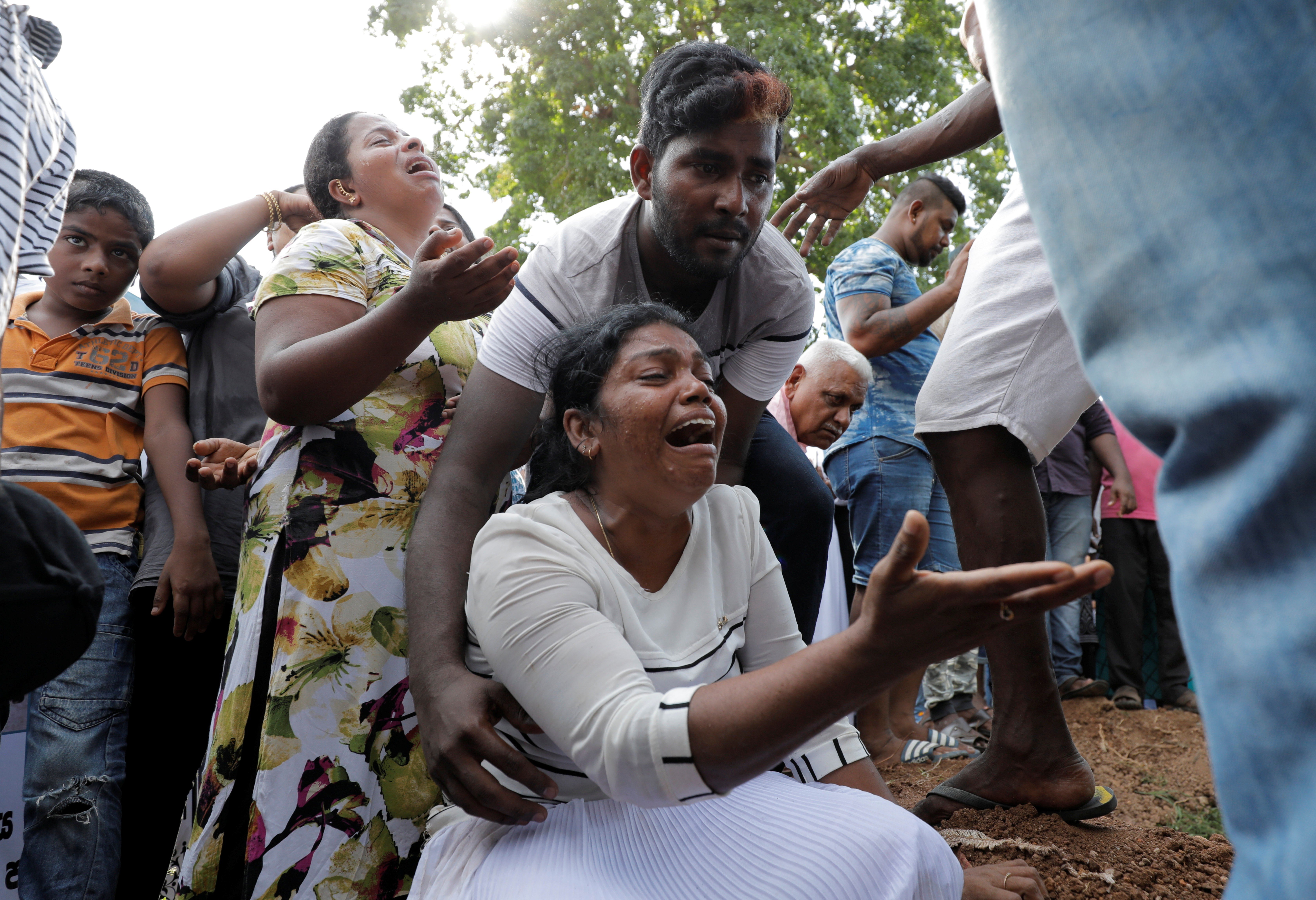 Mourners react during a mass burial of victims, two days after a string of suicide bomb attacks on churches and luxury hotels across the island on Easter Sunday, in Colombo, Sri Lanka April 23, 2019. REUTERS/Dinuka Liyanawatte