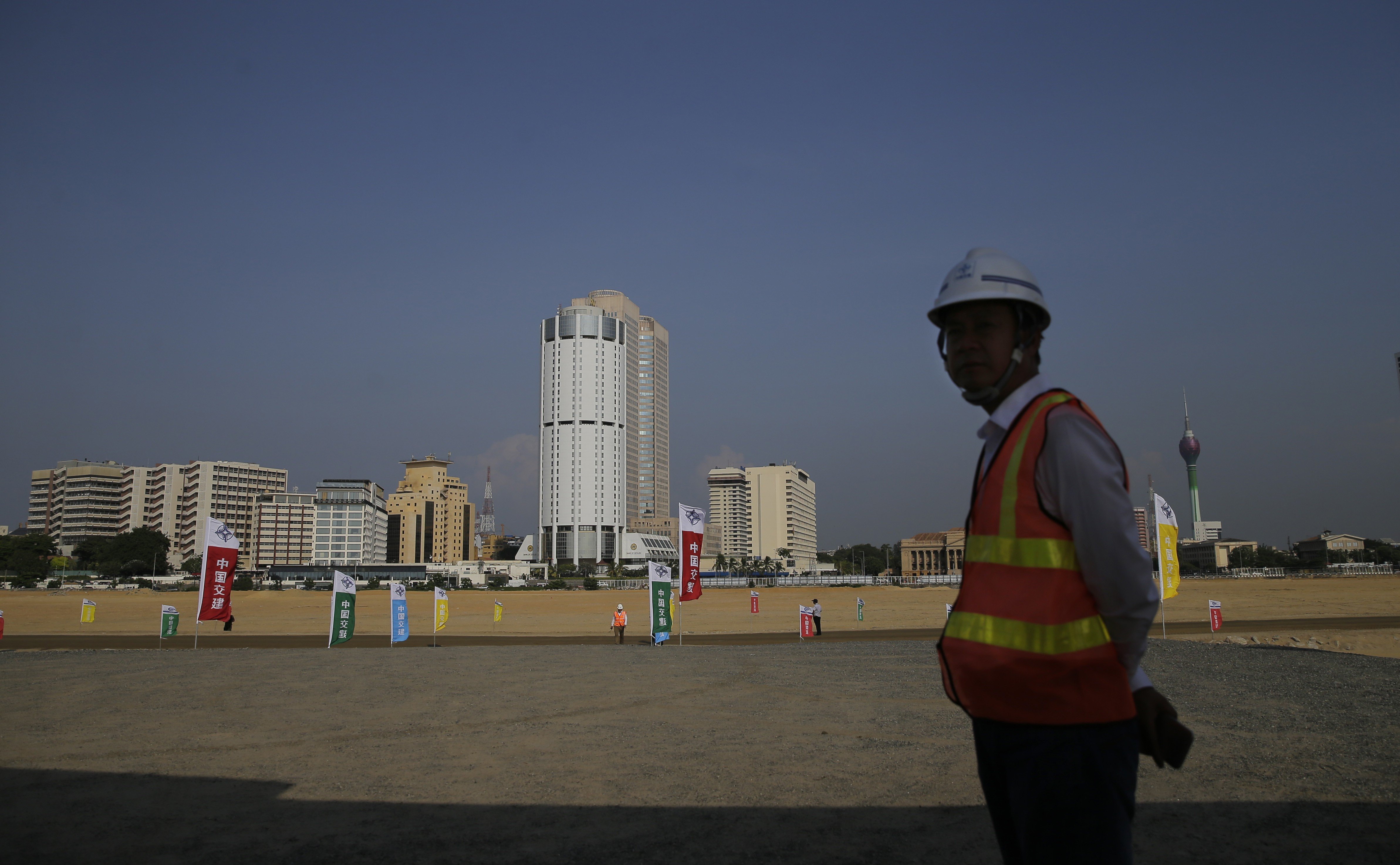 A Chinese construction worker stands on land that was reclaimed from the Indian Ocean for the Colombo Port City project, initiated as part of China's ambitious One Belt One Road initiative. Photo: AP Photo