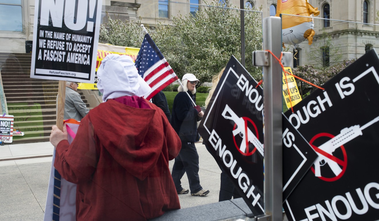 Demonstrators hold signs outside the National Rifle Association Institute for Legislative Action during the NRA annual meeting on Friday. Photo: Bloomberg