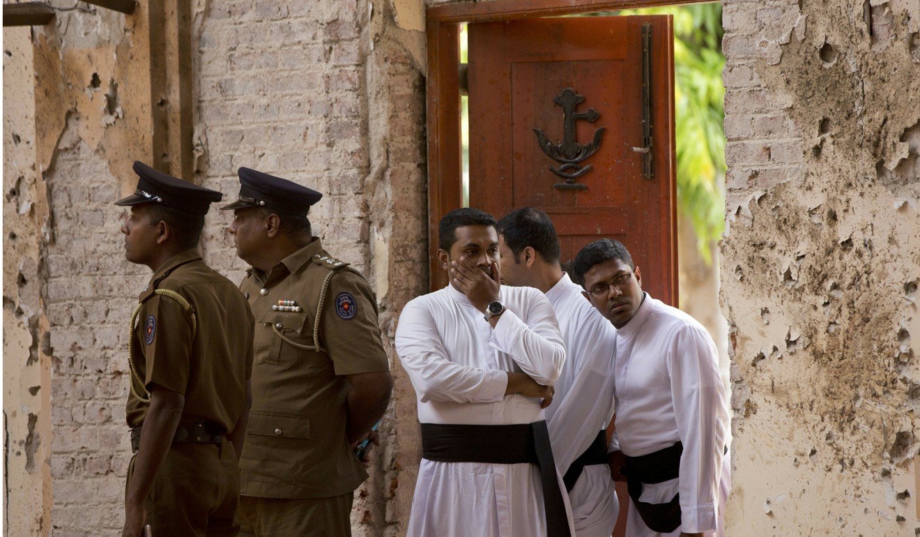Clergymen visit the scene of a suicide bombing at St. Sebastian Church in Negombo. Photo: AP