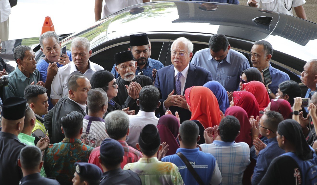 Former Malaysian prime minister Najib Razak greets supporters as he arrives Kuala Lumpur High Court. Photo: AP