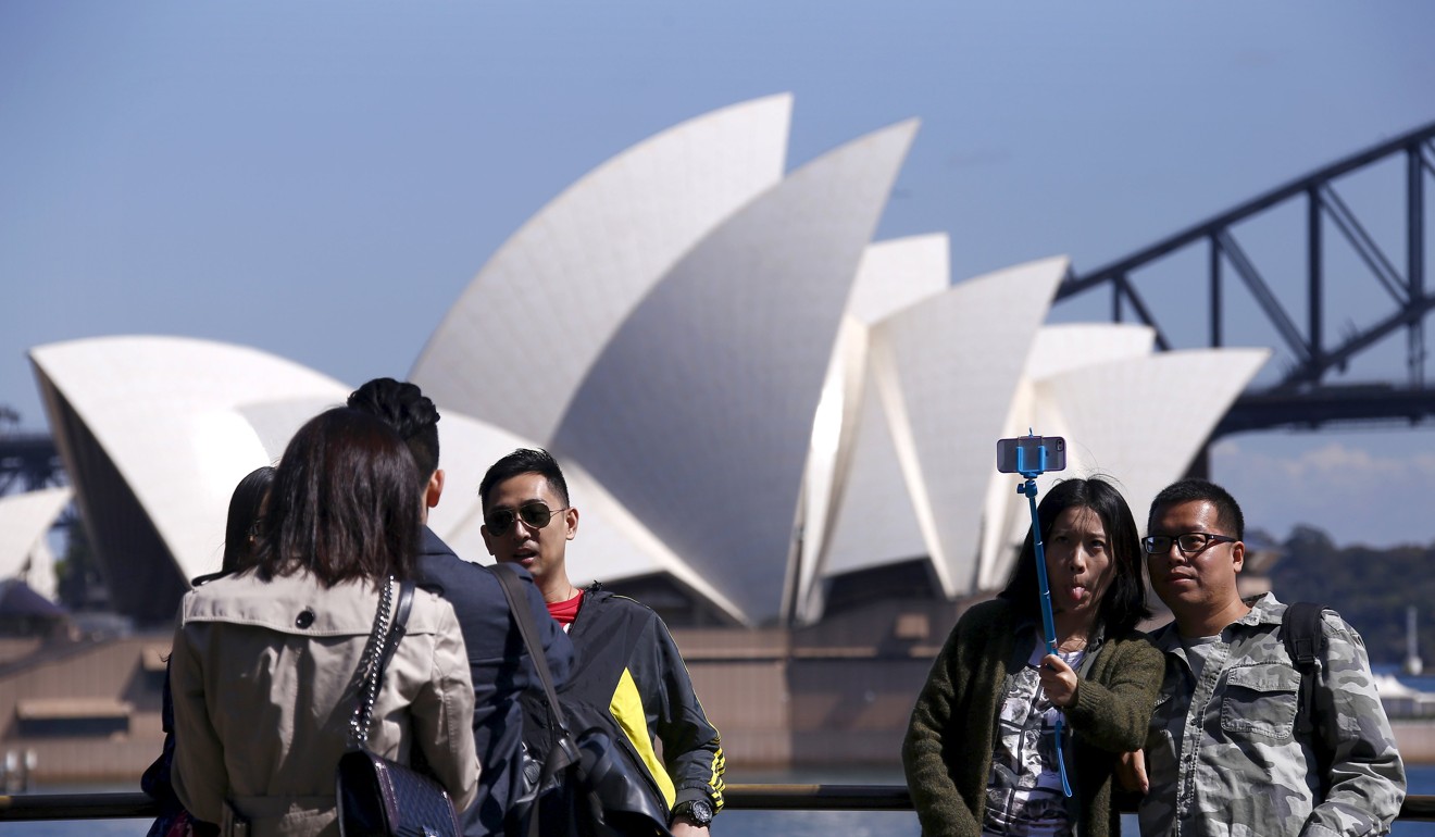 Chinese tourists take pictures of themselves standing in front of the Sydney Opera House in Sydney, Australia. Photo: Reuters