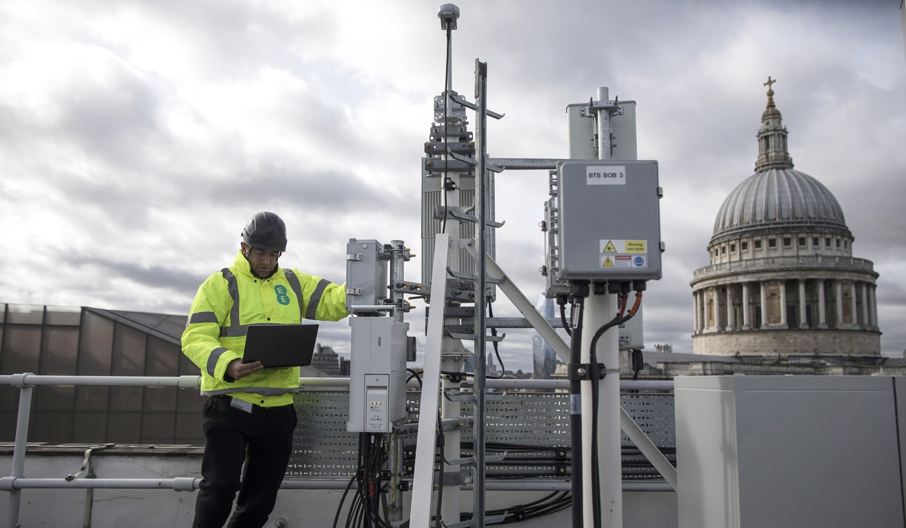 An engineer from EE wireless network provider checks a 5G mast and Huawei equipment on a building in London. Photo: Bloomberg