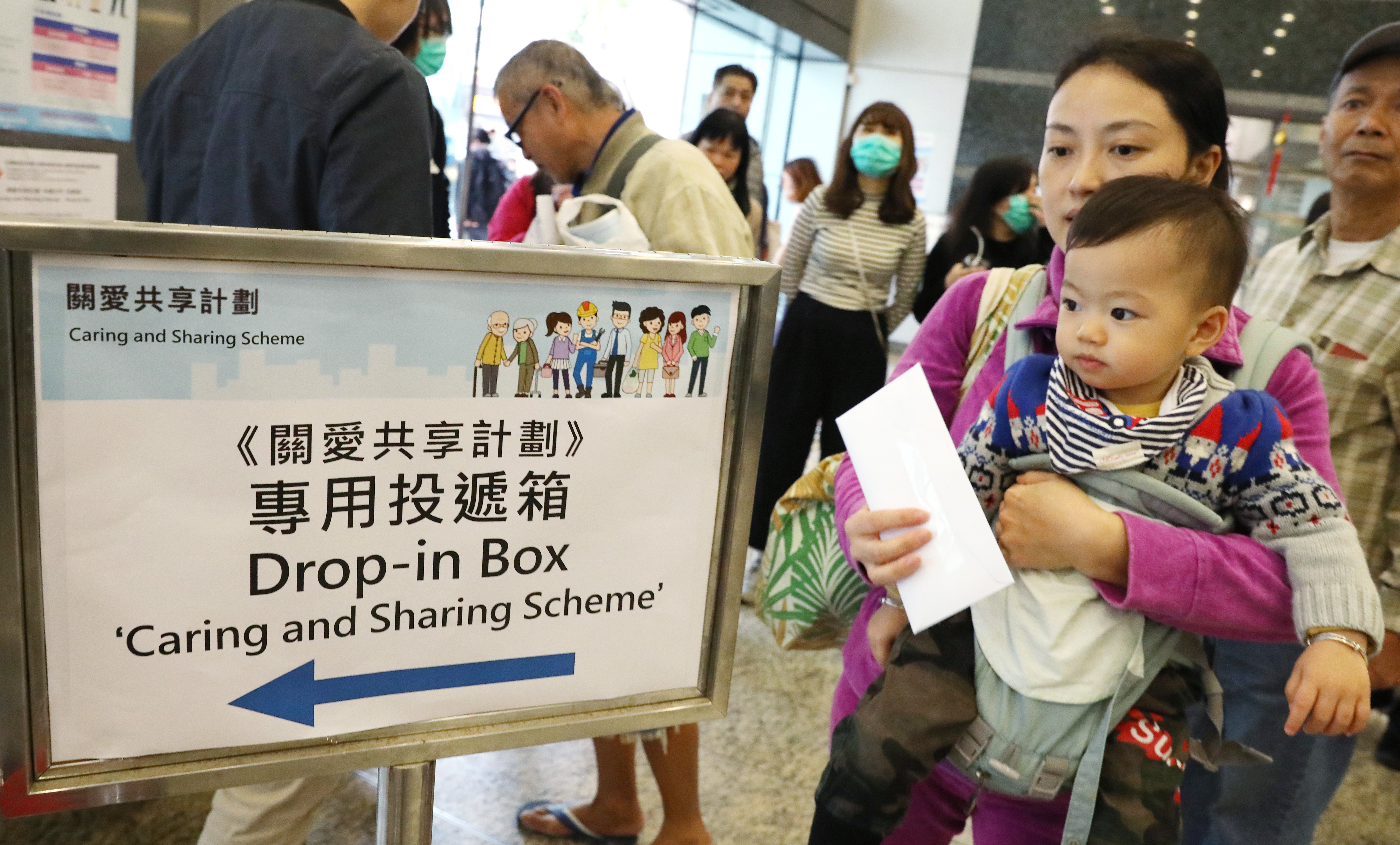 A young mother drops in her application for the Caring and Sharing Scheme at the Cheung Sha Wan Government office in Sham Shui Po. Photo: Dickson Lee