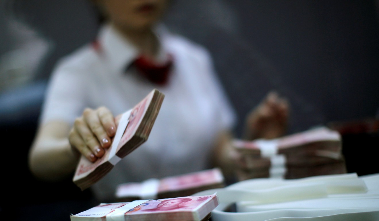 An employee of Industrial and Commercial Bank of China counts money at a branch in the Shanghai free trade zone in Pudong district in September 2014. China reported brisk growth in bank lending in the first quarter of this year. Photo: Reuters