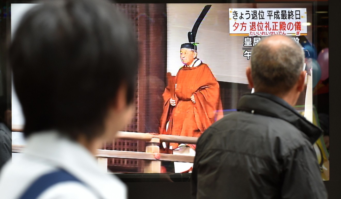 Japanese pedestrians watch coverage of the emperor’s abdication. Photo: AFP