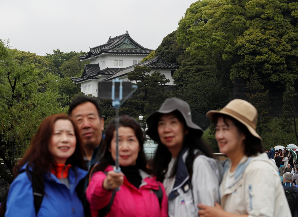 Chinese tourists take photos in front of the Imperial Palace in Tokyo, Japan. Photo: Reuters