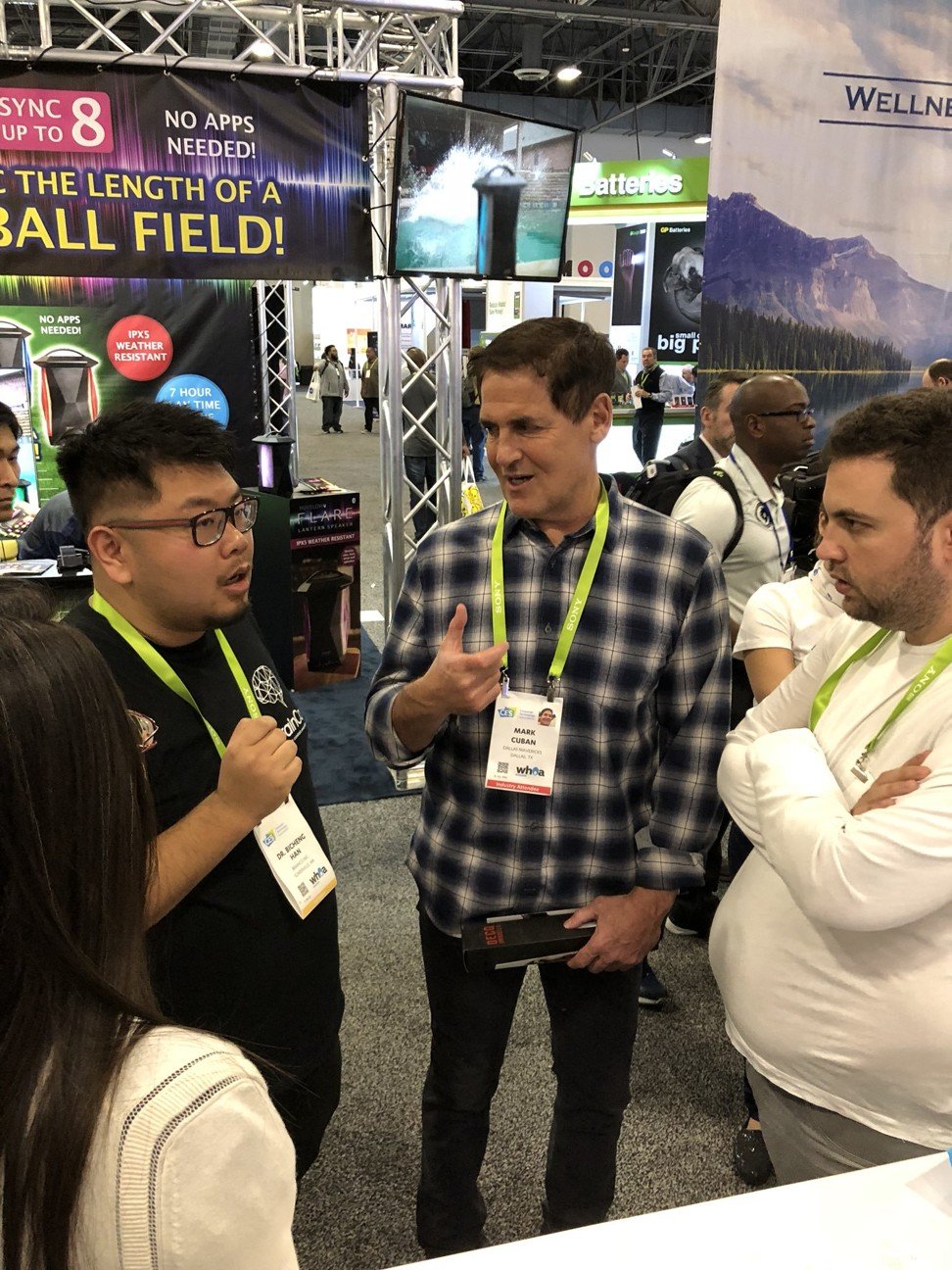 BrainCo chief executive Han Bicheng, left, speaking with US entrepreneur Mark Cuban, centre, at the firm's CES 2018 booth. Picture: Handout