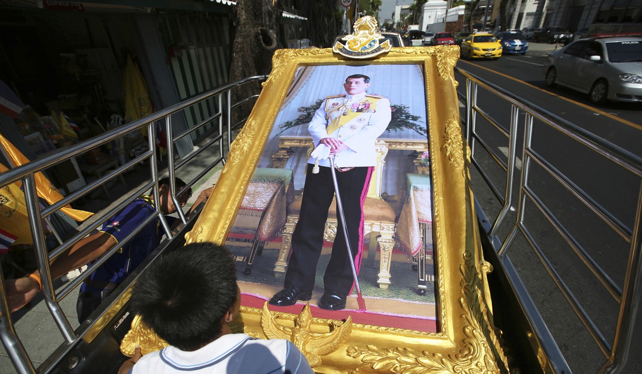 Workers prepare to transport a giant portrait of Thailand's King Maha Vajiralongkorn. Photo: AP