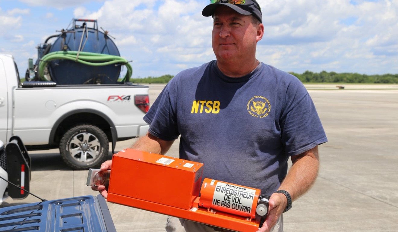 NTSB investigator Dan Boggs holding the flight data recorder. Photo: Reuters