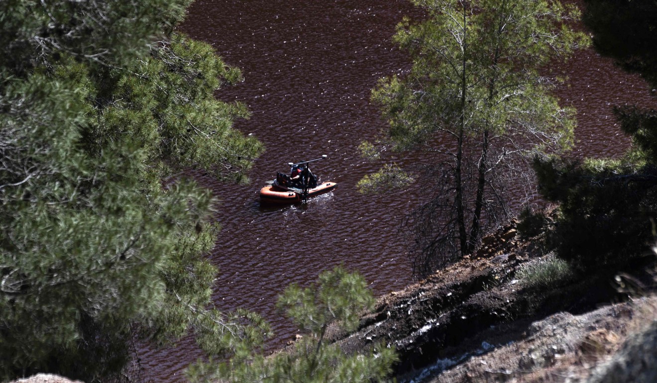 A boat equipped with a sonar system sails on the acidic Red Lake near the village of Mitsero, southwest of the capital Nicosia, during the search for possible bodies of victims of a suspected serial killer. Photo: AFP
