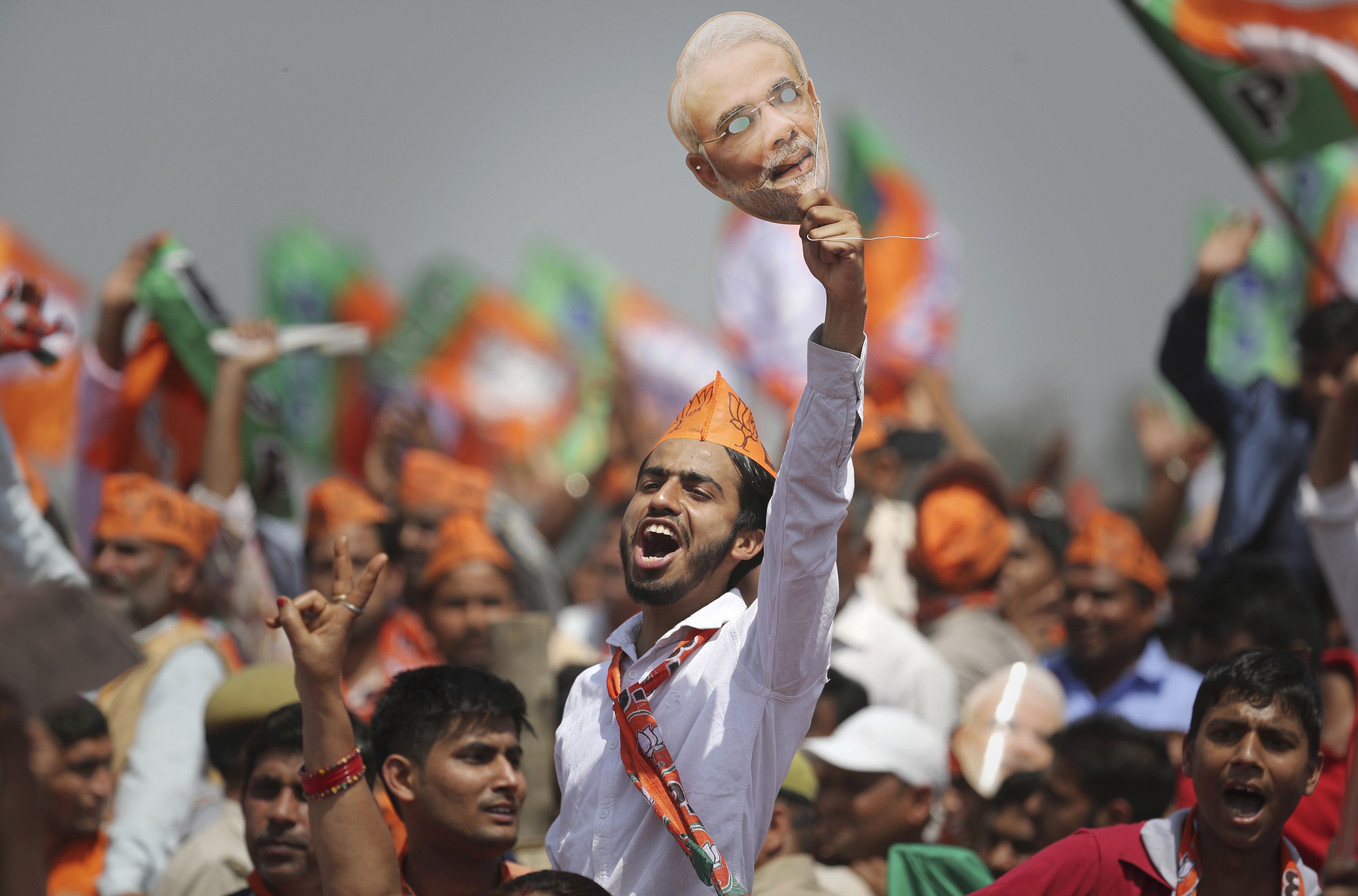 A BJP supporter shouts slogans as he holds up a mask of Indian Prime Minister Narendra Modi during an election rally in Meerut, India, on March 29. Photo: AP