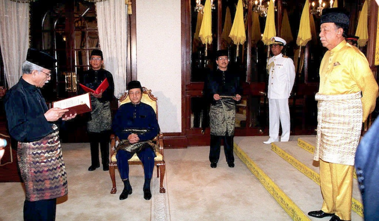 In 1998, Daim Zainuddin (left) takes his oath as Malaysia’s new special functions minister in front of King Tuanku Ja’afar (right), witnessed by Prime Minister Mahathir Mohamad (seated). Photo: AFP