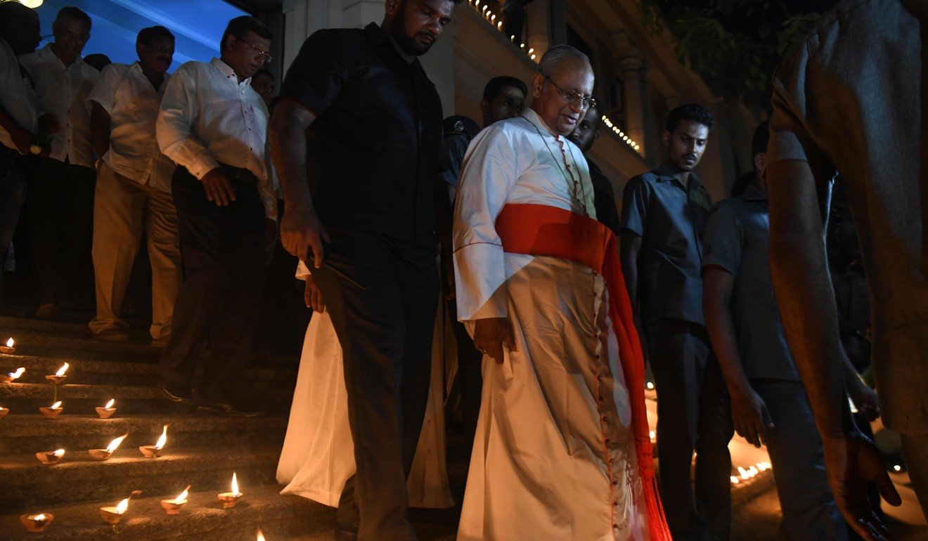 Cardinal Malcolm Ranjith (centre) attends a candlelight vigil on Sunday in memory of bombing victims in Colombo. Photo: AFP
