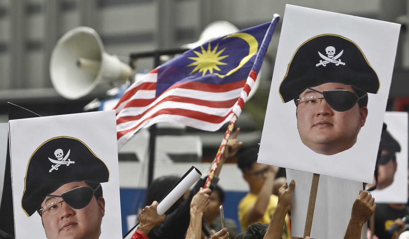 Protesters in Malaysia hold portraits of Jho Low, who is alleged to be at the centre of the 1MDB scandal. Photo: AP