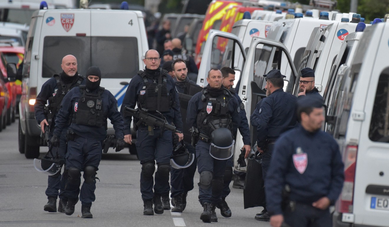 Police officers near the store where a man held four people hostage in Toulouse on Tuesday. Photo: AFP
