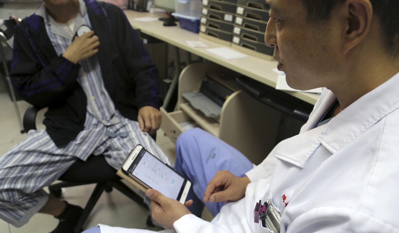 Dr Li Dianyou uses a tablet to adjust the settings of a deep brain stimulation device implanted in Yan’s brain. Photo: AP