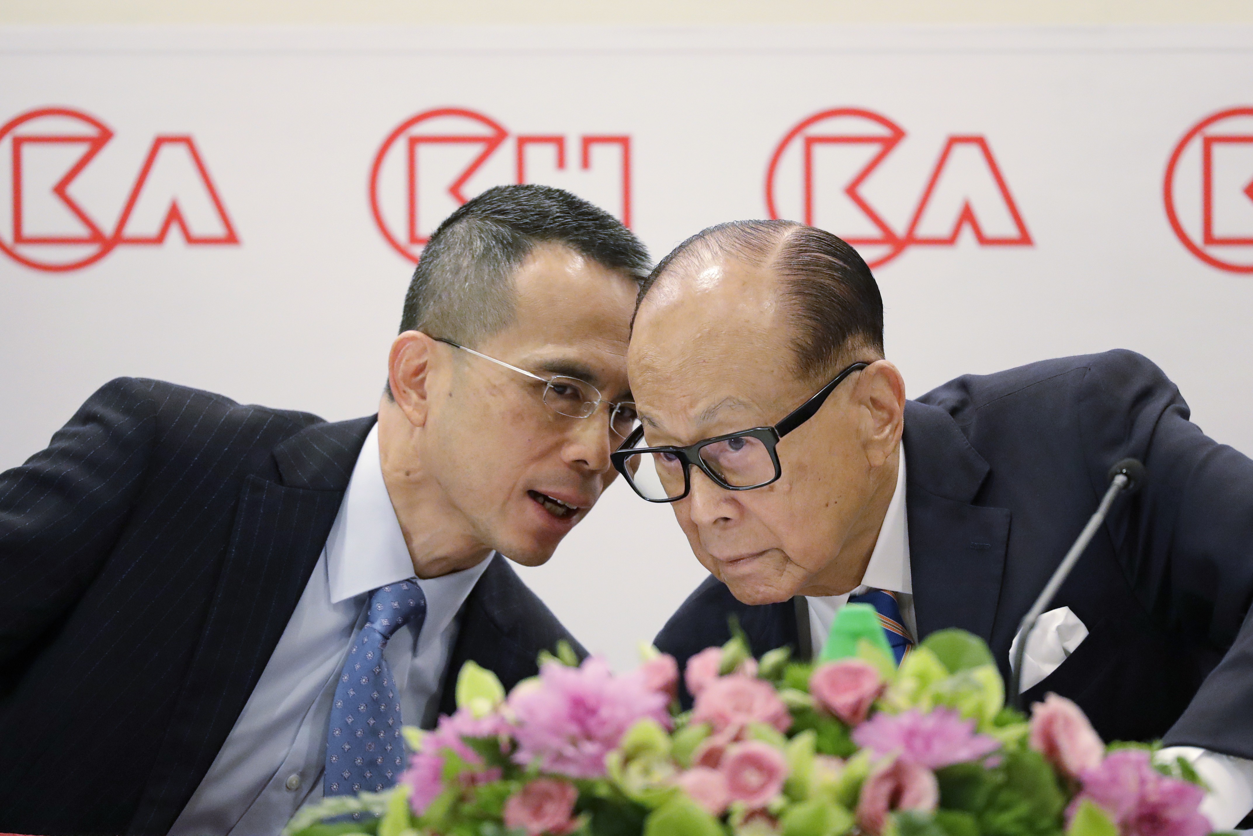 Hong Kong tycoon Li Ka-shing (right) confers with his son Victor Li at CK Hutchison Holdings’ results announcement on March 16, 2018. Since Li Ka-shing’s retirement, Victor Li has taken up his father’s mantle. Photo: AP