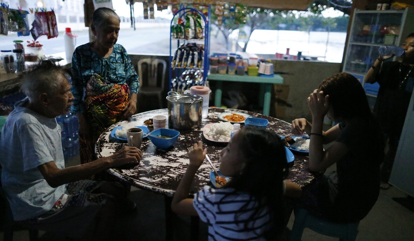 Gubaida Datumanong Dimasangkay (second from left), with her family, after their 14-hour daily fast, at their home in the southern Philippine city of Cotabato. Photo: Jeoffrey Maitem