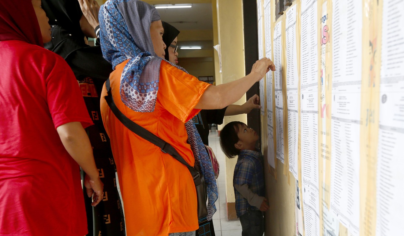 Filipino-Muslims check their names before voting in the midterm elections in Metropolitan Manila. Photo: AP
