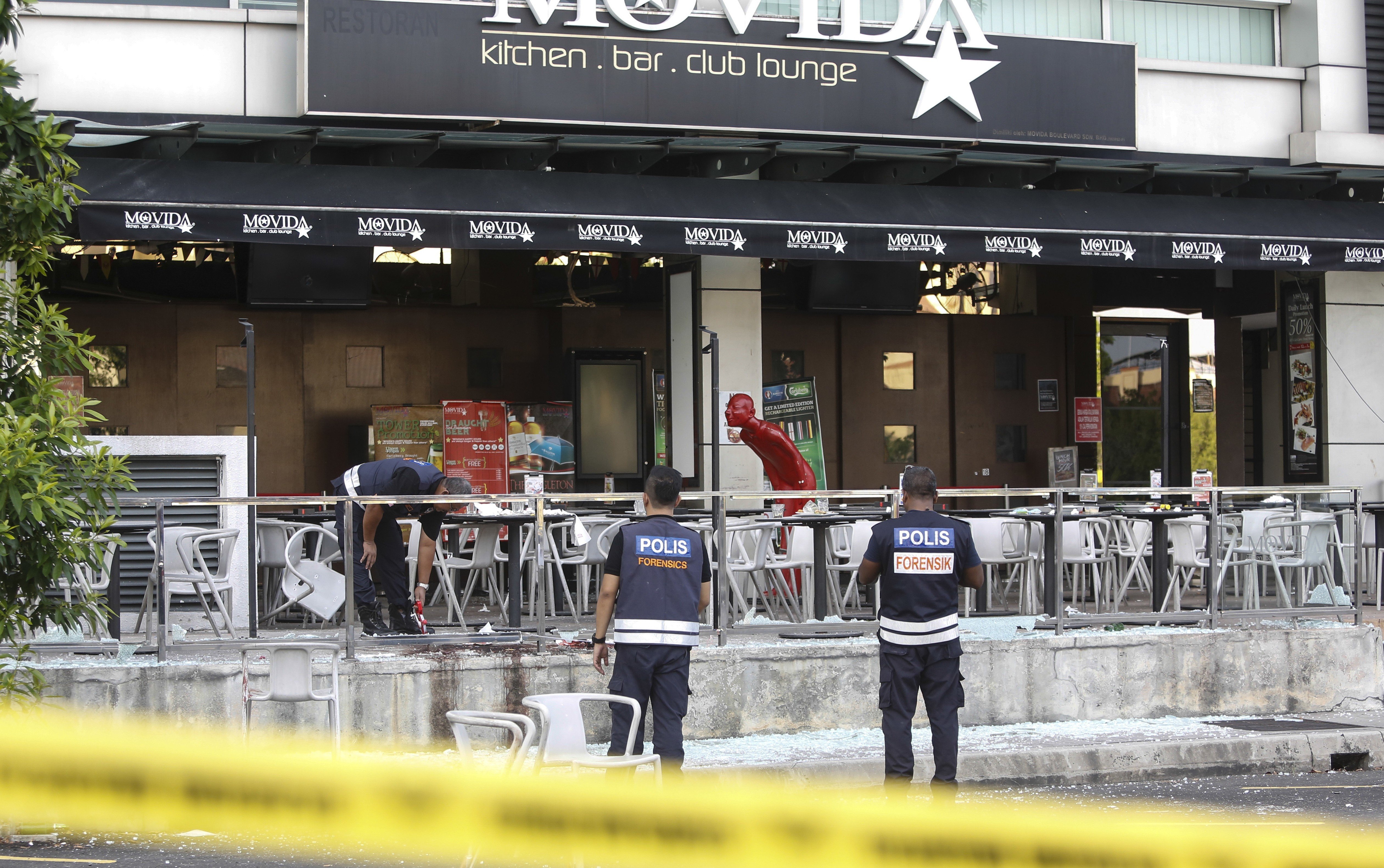 Forensic personnel inspect the site of a grenade attack at a bar and restaurant in Puchong, outside Kuala Lumpur, in 2016. Photo: AP