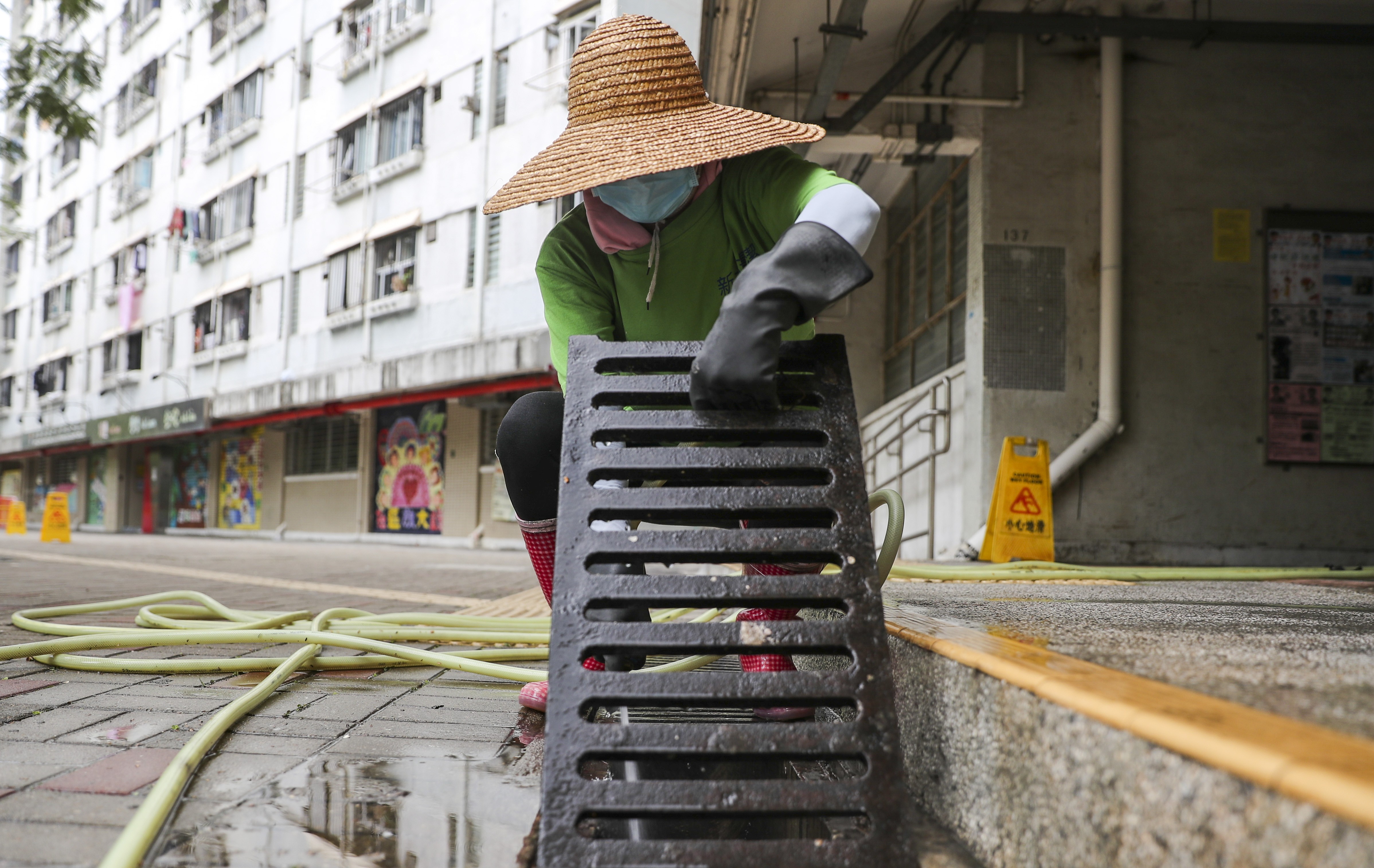 A cleaner tackles the drains at Tuen Mun’s Yau Oi Estate. Photo: Sam Tsang