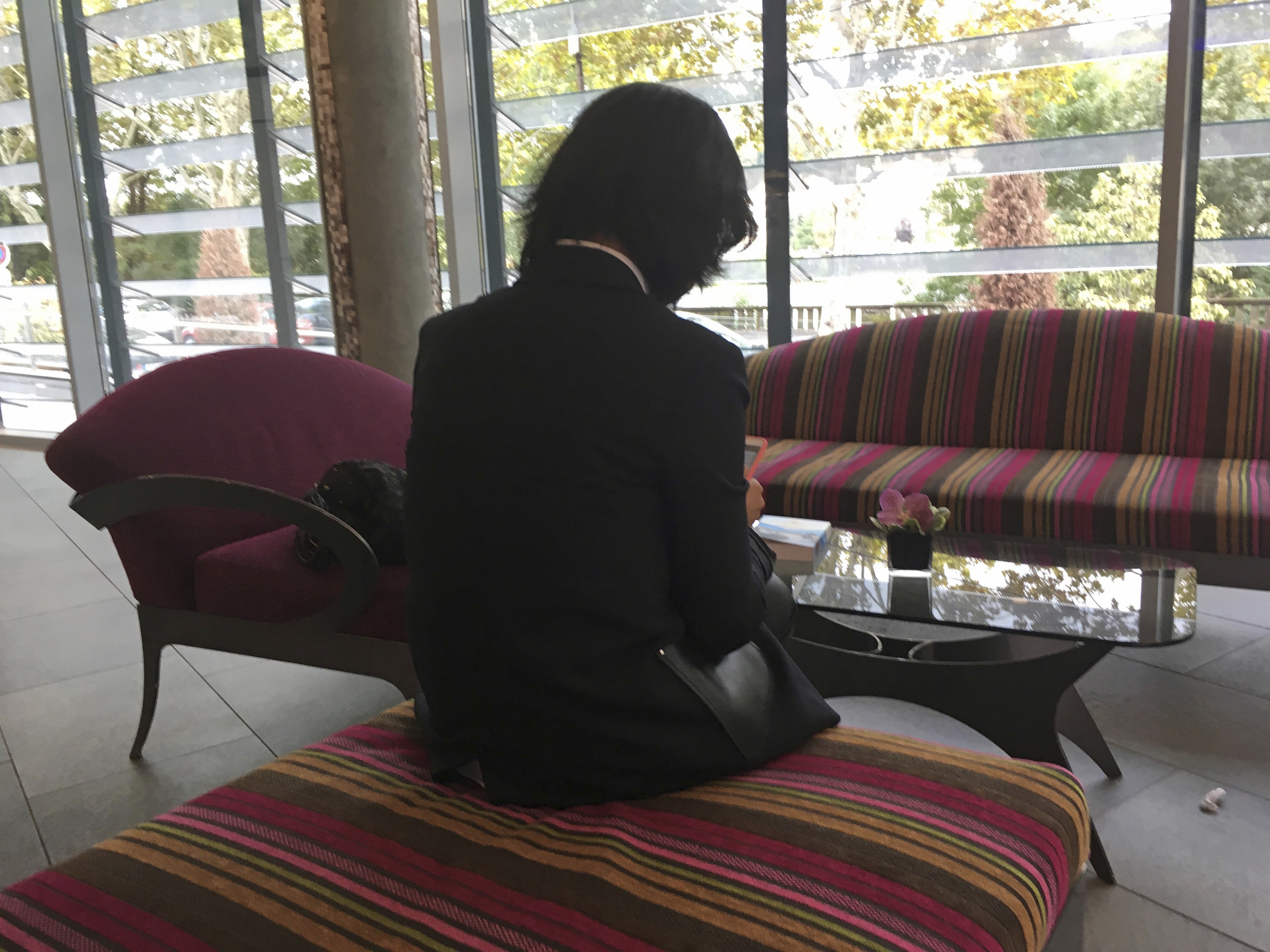Grace Meng, who does not want her face shown, looks at her mobile phone in the lobby of a hotel in Lyon, France, in October. Photo: AP
