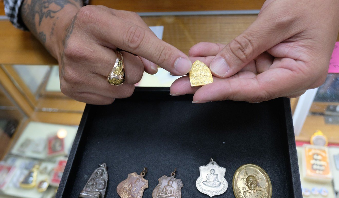 Suthi Utanworapot shows off prized amulets he has for sale. Photo: Tibor Krausz