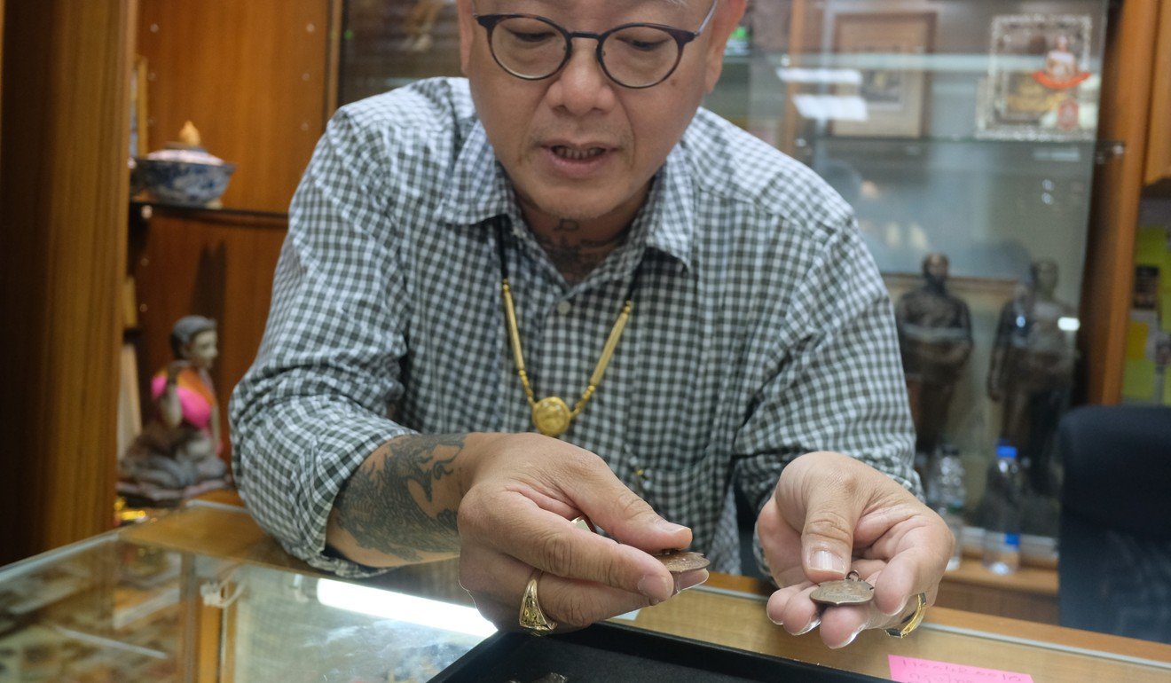 “Amulet master” Suthi Utanworapot shows off some special amulets in his shop at a Bangkok amulet market. Photo: Tibor Krausz