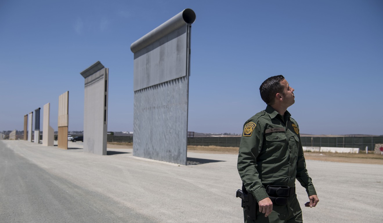 Border Patrol Public Affairs Officer Vincent Pirro looks at border wall prototypes in San Diego in April. Photo: Carolyn Van Houten via The Washington Post