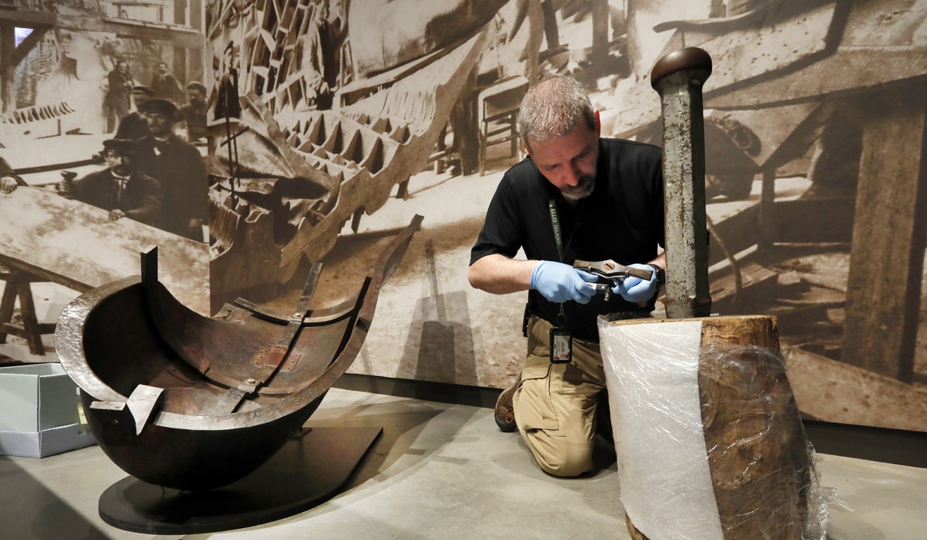 A worker arranges tools in a display of an iron armature in the new Statue of Liberty Museum. Photo: AP