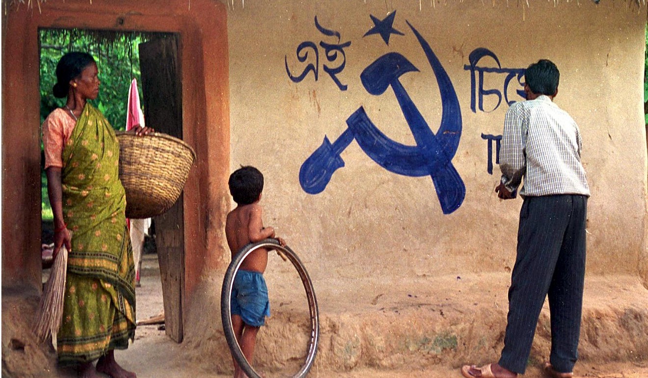 A man paints a communist symbol on a hut in West Bengal. Photo: AFP