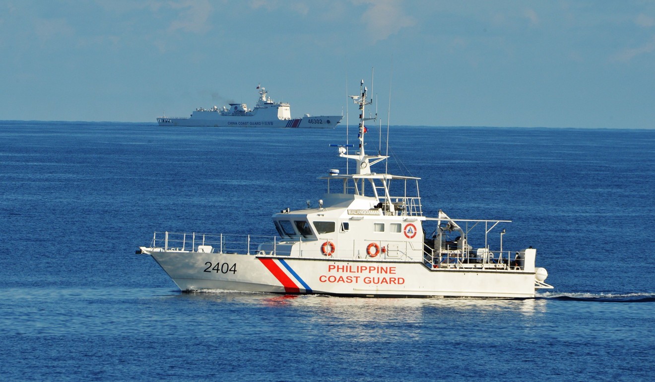 A Philippine coastguard ship in the South China Sea with a Chinese vessel in the background. Photo: AFP