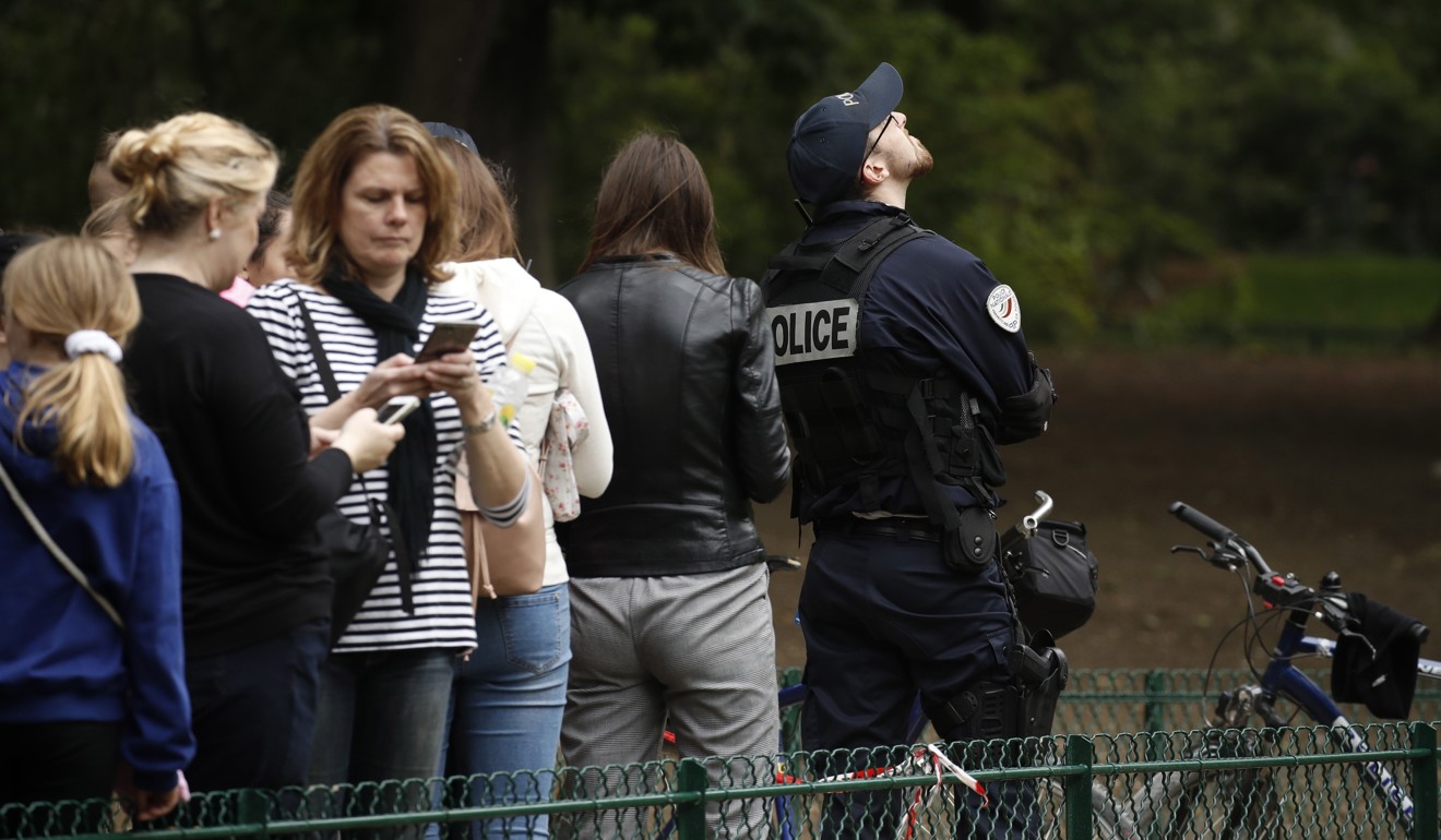 Police evacuate tourists as a man climbs the Eiffel Tower in Paris on Monday. Photo: EPA-EFE