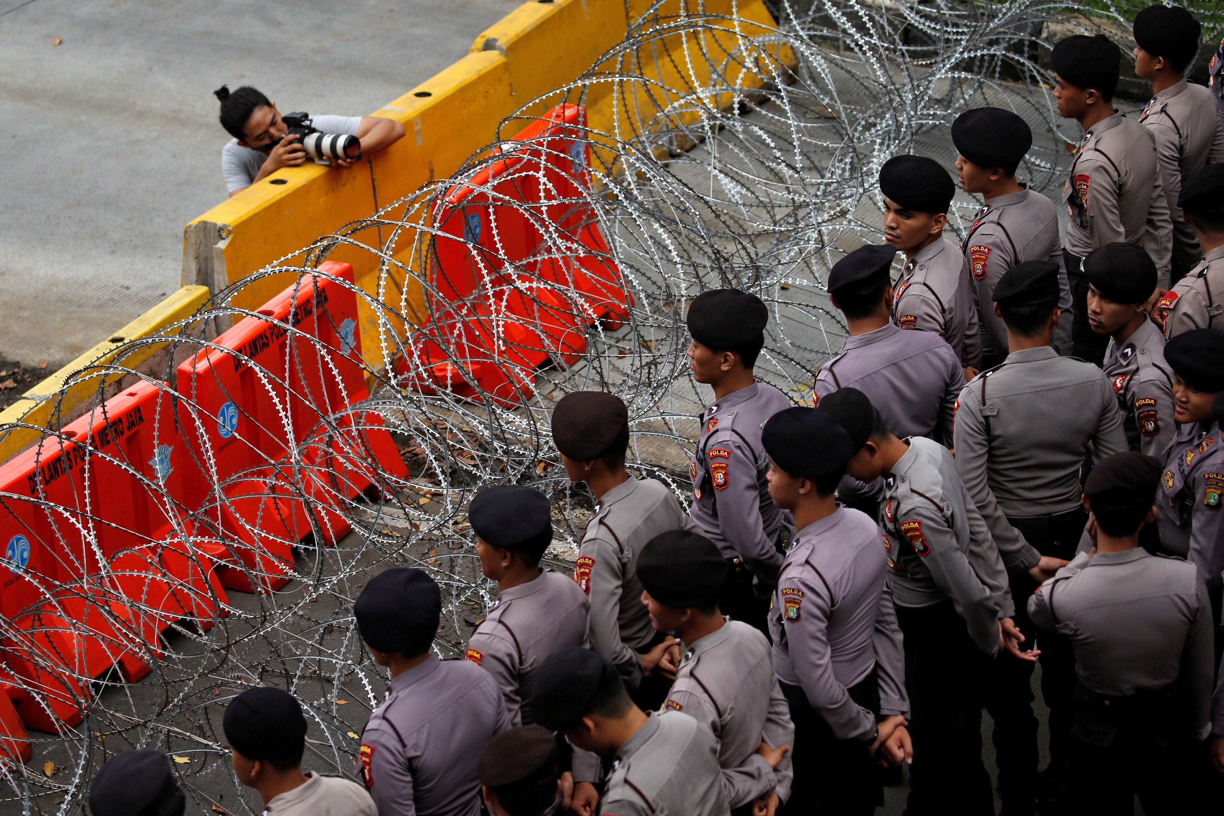 Indonesian police officers stand guard during a May Day rally near the National Monument (Monas) in Jakarta. Photo: Reuters