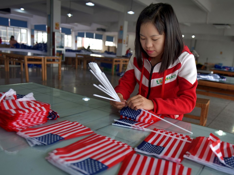 A Chinese employee makes US national flags at a factory in Wuyi in China's eastern Zhejiang province. Photo: AFP